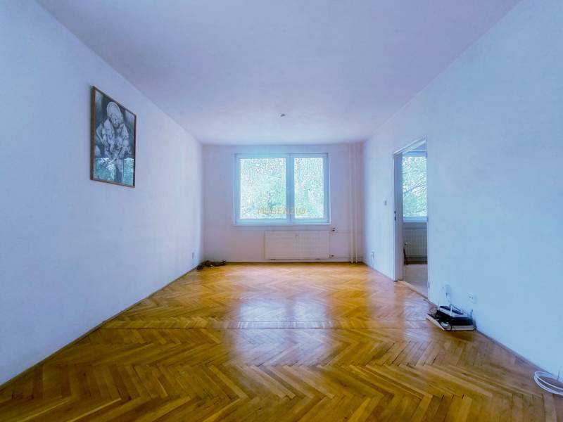 Ein geräumiges Zimmer mit Holzboden und einem Bild an der Wand in einer 3-Zimmer-Wohnung.