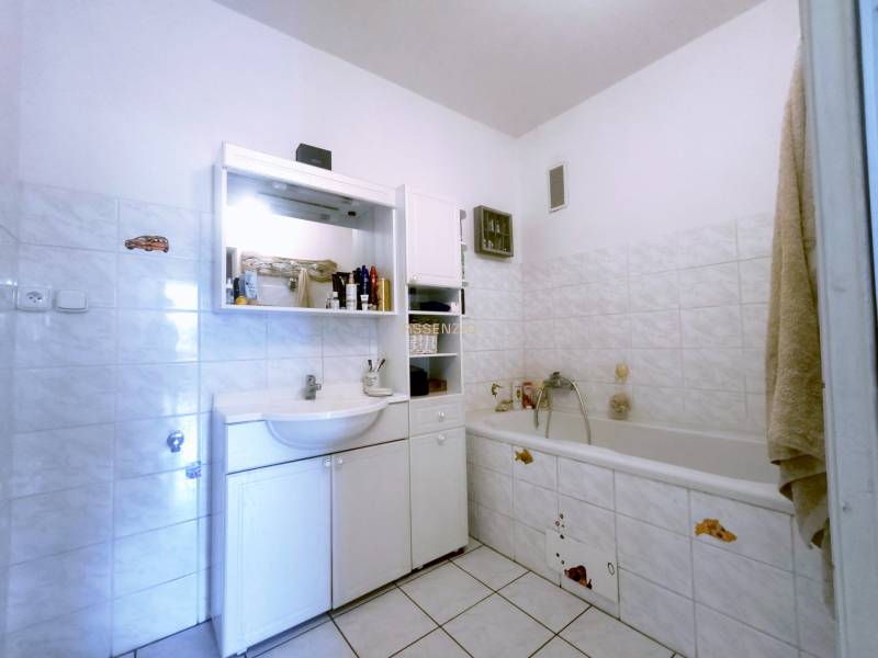 Badezimmer in einer 3-Zimmer-Wohnung mit Badewanne, Waschbecken und Stauraum.