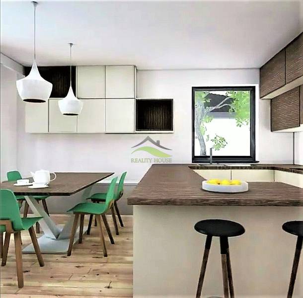 Küche in einem Einfamilienhaus mit grünen Stühlen, Holzboden und großem Fenster.