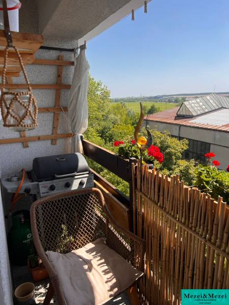 Balkon einer 3-Zimmer-Wohnung mit Sitzgelegenheit, Grill und Blick ins Grüne in Pezinok.