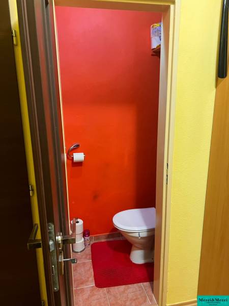 Ein Badezimmer mit hellorangenen Wänden und einem roten Teppich, 3-Zimmer-Wohnung.