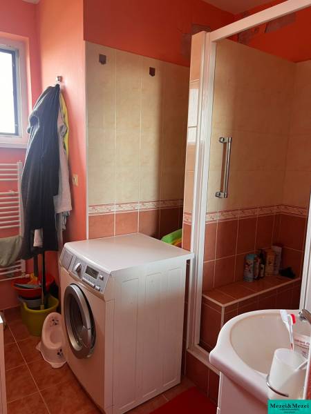 Badezimmer in einer 3-Zimmer-Wohnung mit Waschmaschine und Duschkabine.