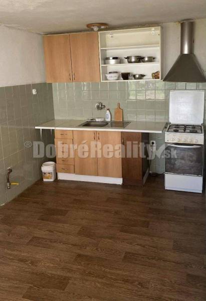 Küche in einem Einfamilienhaus mit Herd, Arbeitsplatte, Schränken und Dunstabzugshaube.