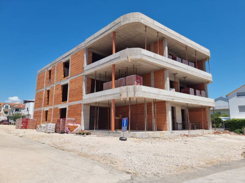 Ein im Bau befindliches Gebäude mit einer 3-Zimmer-Wohnung in der Stadt Vodice an einem sonnigen Tag.
