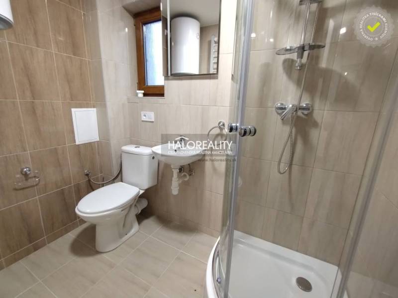 Badezimmer in einem Studio-Apartment mit Toilette, Waschbecken, Duschkabine und Fenster.