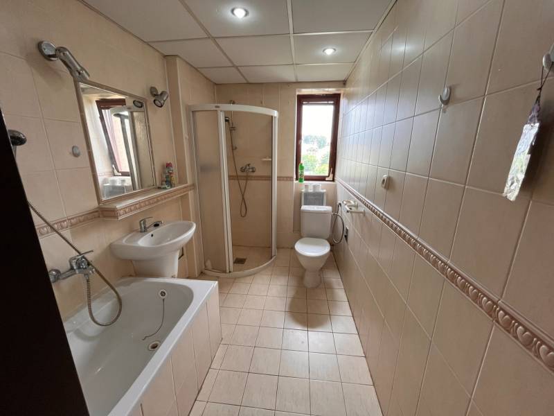 Badezimmer in einer 2-Zimmer-Wohnung mit Badewanne, Dusche, Waschbecken und Toilette.
