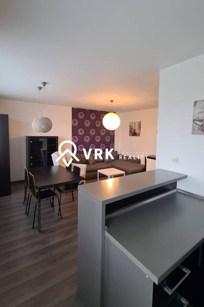 Wohnzimmer in einer 2-Zimmer-Wohnung mit Essbereich und Sofa, Kronleuchter und Dekorationen.