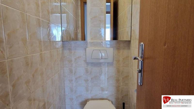 Toilette in einem Einfamilienhaus mit Wandfliesen und einem Wandspülkasten.