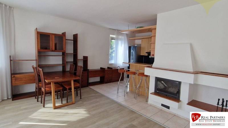 Wohnzimmer in einem Einfamilienhaus mit Holzmöbeln und Kamin, Esstisch und Stühlen.