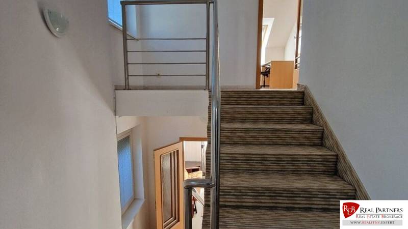 Eine Treppe mit Teppich und Geländer in einem Einfamilienhaus, die Räume schaffen eine gemütliche Atmosphäre.