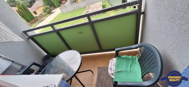 Balkon einer 3-Zimmer-Wohnung mit einem Plastikstuhl und einem kleinen Glastisch.