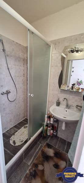 Ein Badezimmer in einer 3-Zimmer-Wohnung mit Duschkabine und Waschbecken, voller Tageslicht.