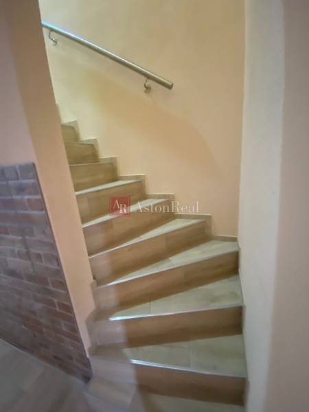 Treppe in einem Einfamilienhaus mit Ziegelwand und Stahlgeländer.
