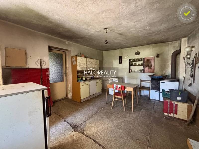 Eine Küche in einem Einfamilienhaus mit ländlichem Flair, enthält einen Herd und einen Esstisch.