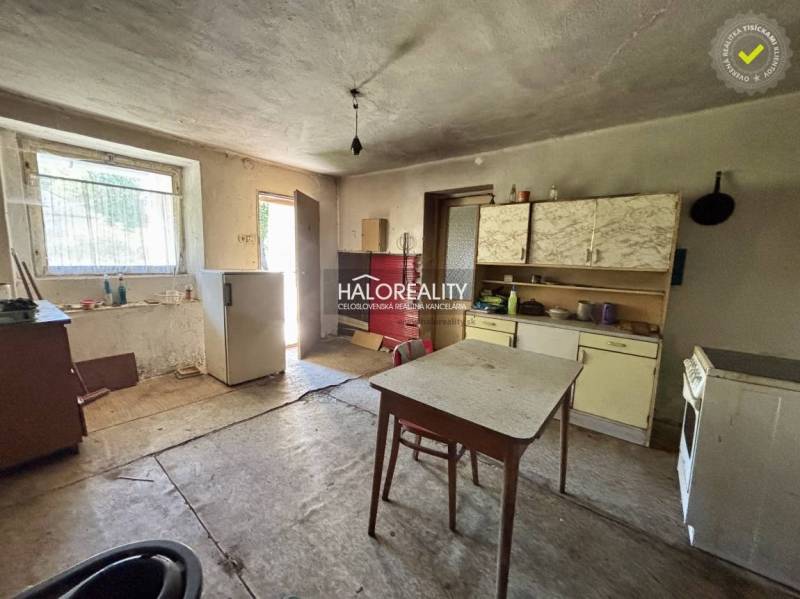 Küche in einem Einfamilienhaus mit einfacher Einrichtung und älteren Möbeln.