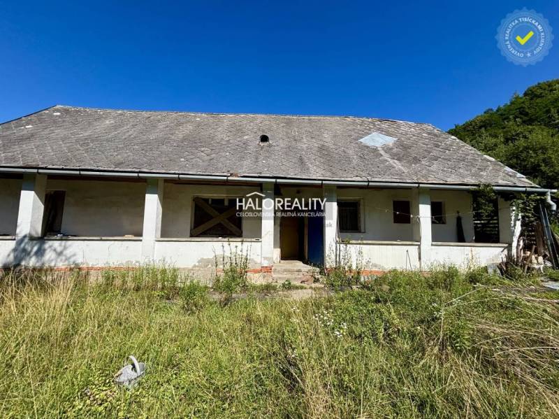 Ein Einfamilienhaus in Turčok mit Renovierungsbedarf, umgeben von Grün und blauem Himmel.