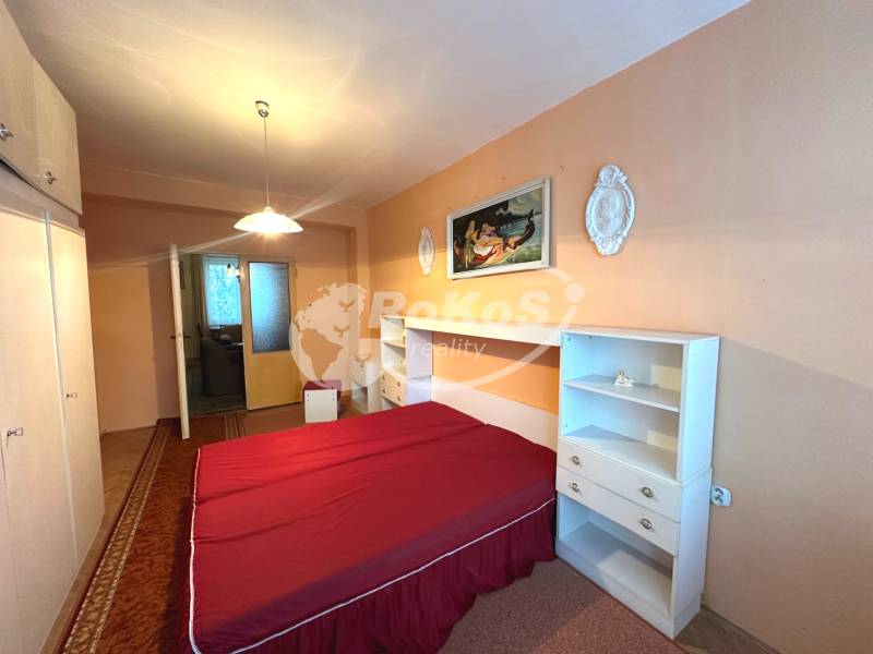 Schlafzimmer in einer 3-Zimmer-Wohnung mit Doppelbett, Schrank und Wanddekorationen.