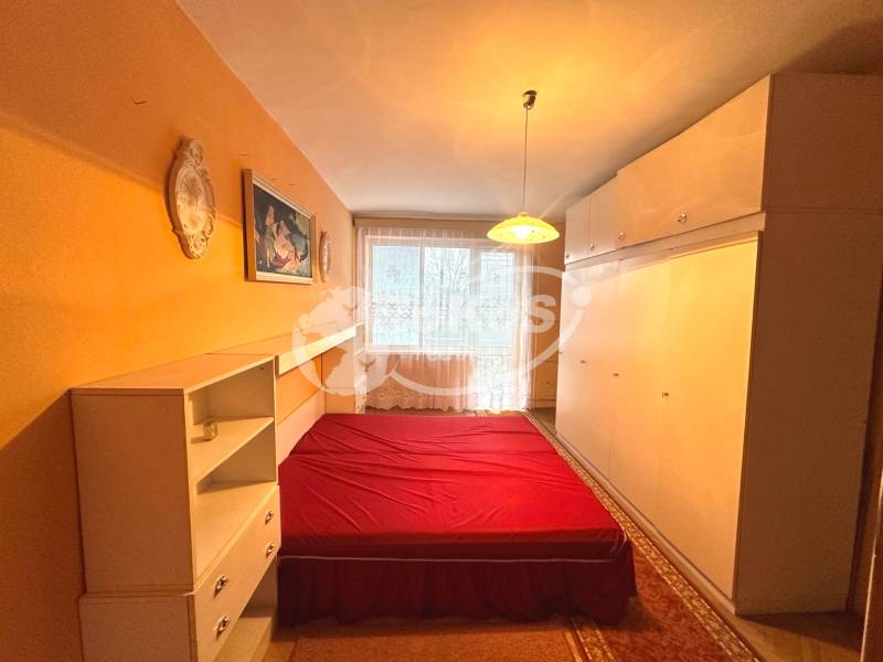 Schlafzimmer mit Einbauschränken, Bett mit roter Decke in einer 3-Zimmer-Wohnung.