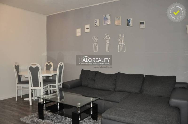 Wohnzimmer mit grauem Sofa und Esstisch in einer 3-Zimmer-Wohnung.