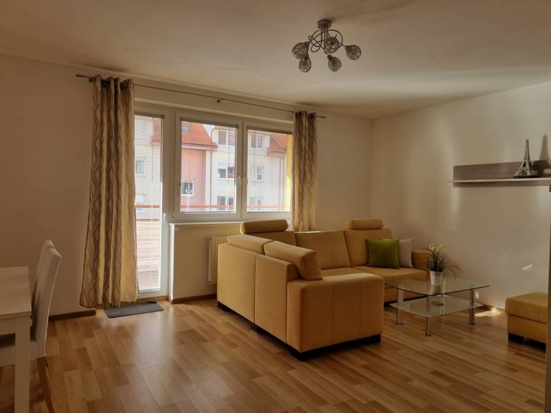 Wohnzimmer mit bequemer Couch und Glastisch in einer 2-Zimmer-Wohnung.