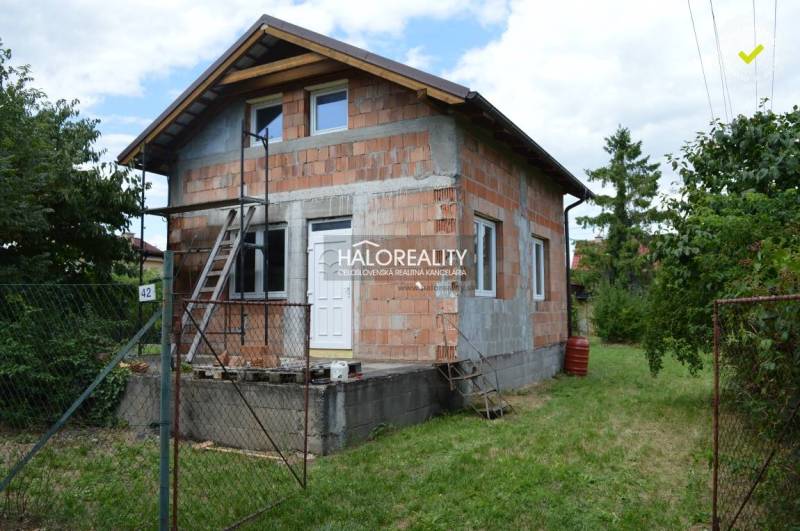 Eine Hütte in Vinosady, gebaut aus Ziegeln, mit einer Leiter und grüner Umgebung.