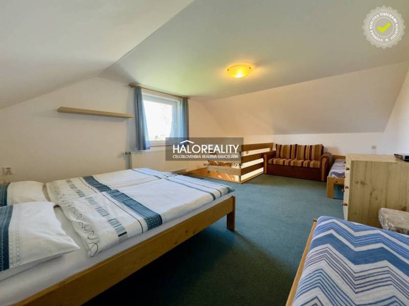 Schlafzimmer in einem Einfamilienhaus mit Betten, Sofa und Teppich.