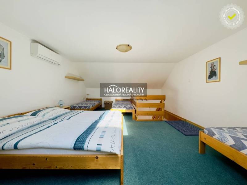 Ein Dachzimmer in einem Einfamilienhaus mit Klimaanlage und Holzbett.
