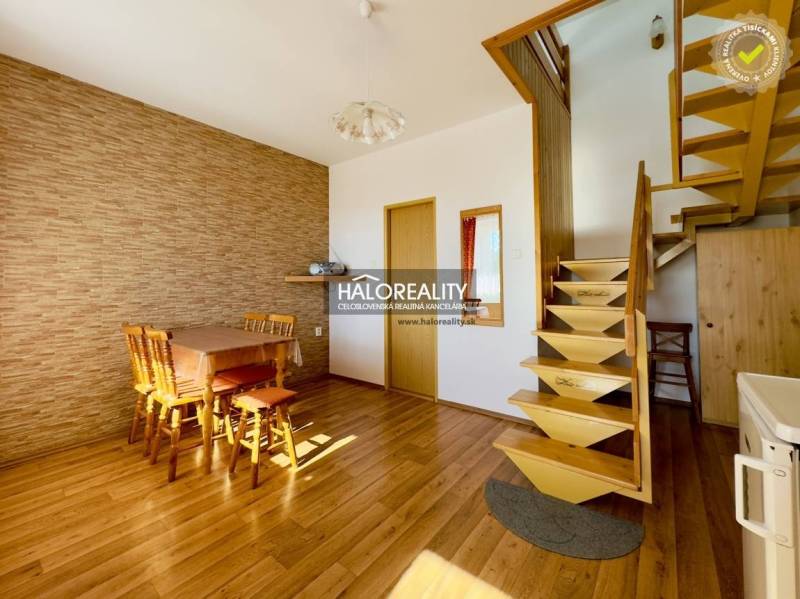 Innenraum eines Einfamilienhauses mit Holztreppe, Essecke und Holzboden.