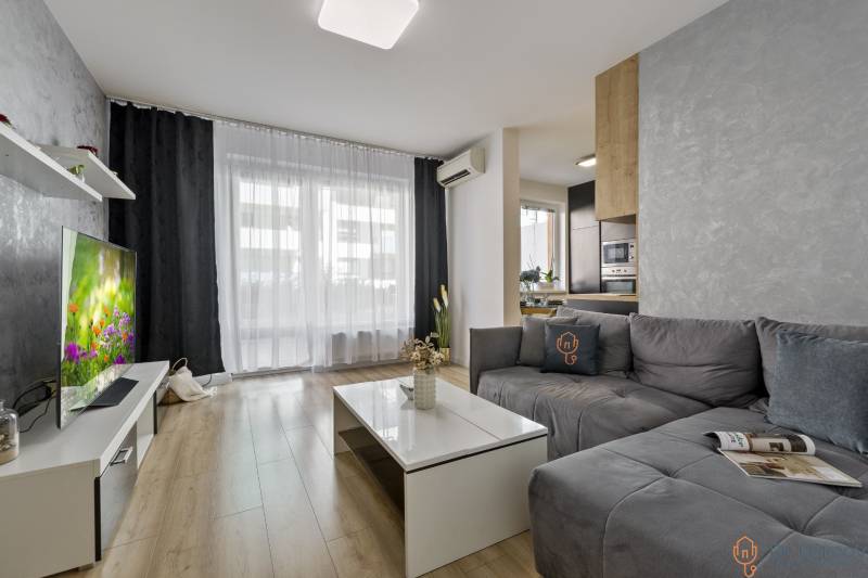 Wohnzimmer mit Sofa und Fernseher in einer Zweizimmerwohnung.