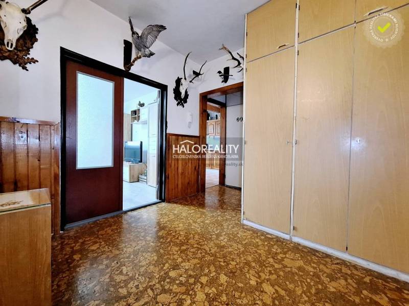 Eingangsbereich in einer 3-Zimmer-Wohnung mit Holzverkleidung, Kleiderhaken und Einbauschränken.