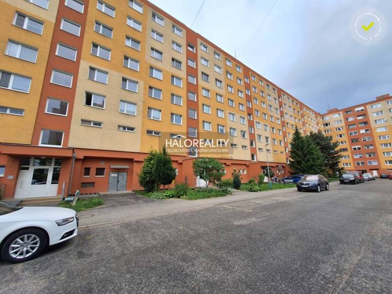 Ein Wohnblock mit 3-Zimmer-Wohnungen in Prievidza, umgeben von Grünflächen und einem Parkplatz.