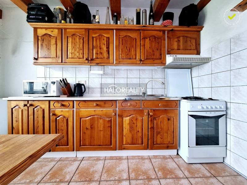 Rustikale Küche mit Schränken, Backofen und Geräten in einer 3-Zimmer-Wohnung.