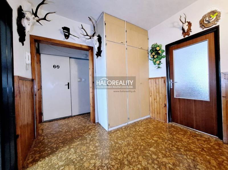 Ein Flur mit Holzvertäfelung, Schränken und Trophäen in einer 3-Zimmer-Wohnung.