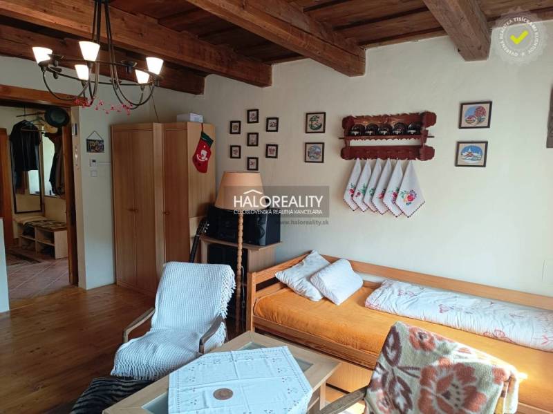 Das Innere der Hütte mit einer Holzdecke, bequemen Sitzgelegenheiten und Wanddekorationen.