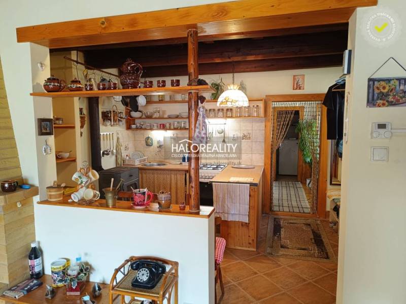 Eine Küche in einer Hütte mit Holzverkleidung, traditionellem Touch und Keramik-Accessoires.