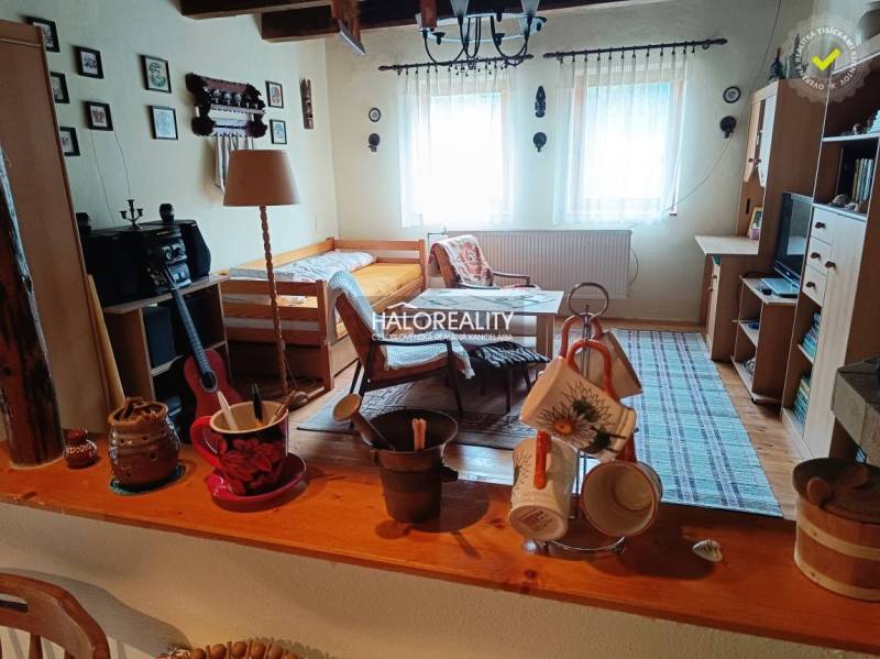 Gemütliches Zimmer in einer Hütte mit Tisch, Bett und dekorativen Gegenständen.