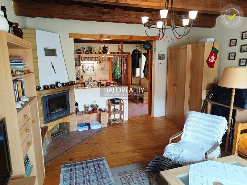 Das Innere der Hütte mit Kamin, Holzbalkendecke, gemütlichen Accessoires und bequemen Möbeln.