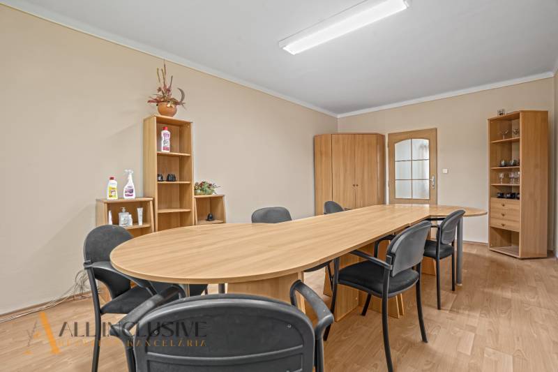 Besprechungsraum: Holztisch, Stühle, Schränke und Regale im Büro.