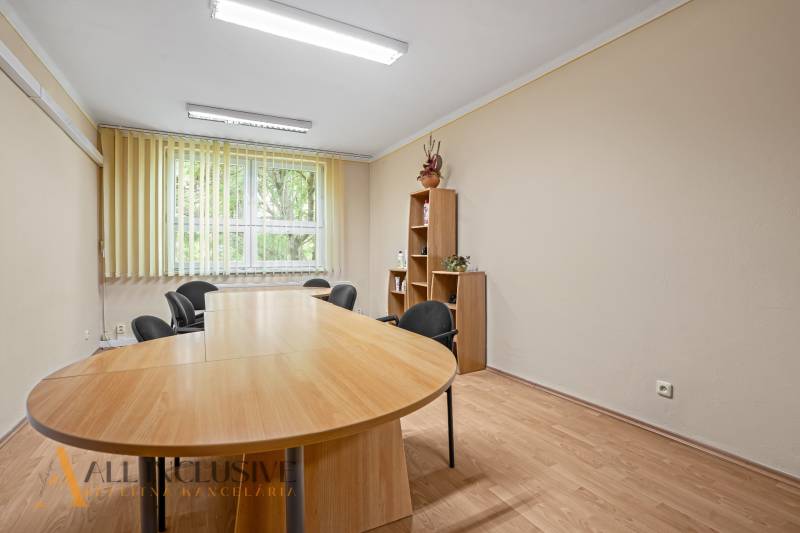 Esstisch mit Bücherregal und Bürostühlen im Büro.