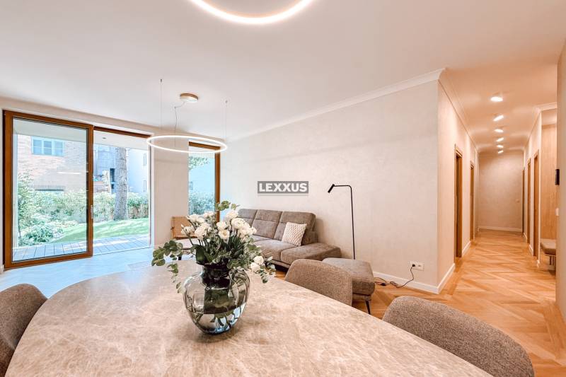 Ein stilvoller Wohnbereich mit einem Sofa und einer Vase mit Blumen in einer 4-Zimmer-Wohnung.