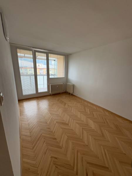 Ein Zimmer in einer 2-Zimmer-Wohnung mit Parkettboden und einem großen Fenster mit Aussicht.