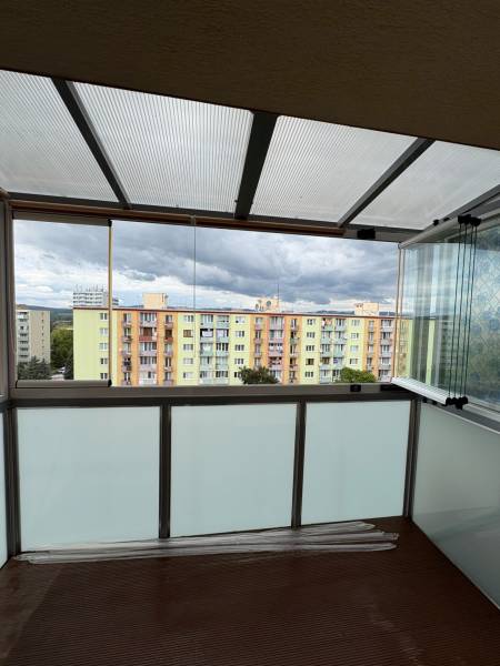Ein verglaster Balkon mit Blick auf die bunten Wohnblöcke in Nová Dubnica in der SNP-Straße.