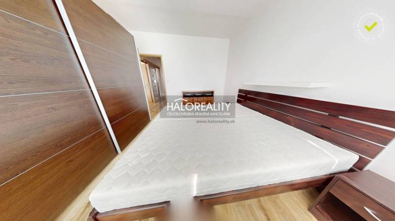 Schlafzimmer in einer 3-Zimmer-Wohnung mit Einbauschrank und Bett mit Matratze.