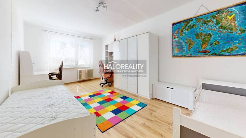 Kinderzimmer in einer 3-Zimmer-Wohnung mit einem bunten Teppich und einem Schreibtisch.
