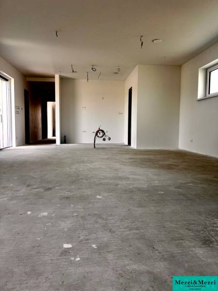 Ein leerer Raum mit Betonboden, bereit zur Fertigstellung in einem Einfamilienhaus.
