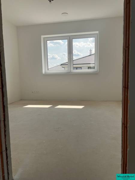 Blick auf einen leeren Raum mit Fenster in einem Einfamilienhaus, Aussicht auf die Dächer.