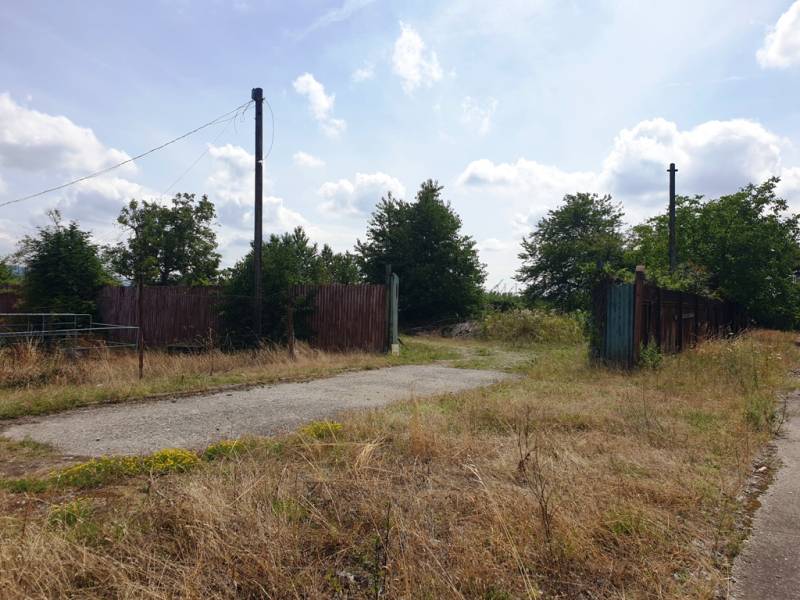 Grundstück - Gewerbe in Trenčianske Bohuslavice mit alten Zäunen und einer kaputten Straße.
