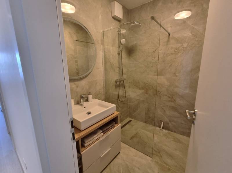 Badezimmer mit Dusche und Waschbecken in einer 3-Zimmer-Wohnung.