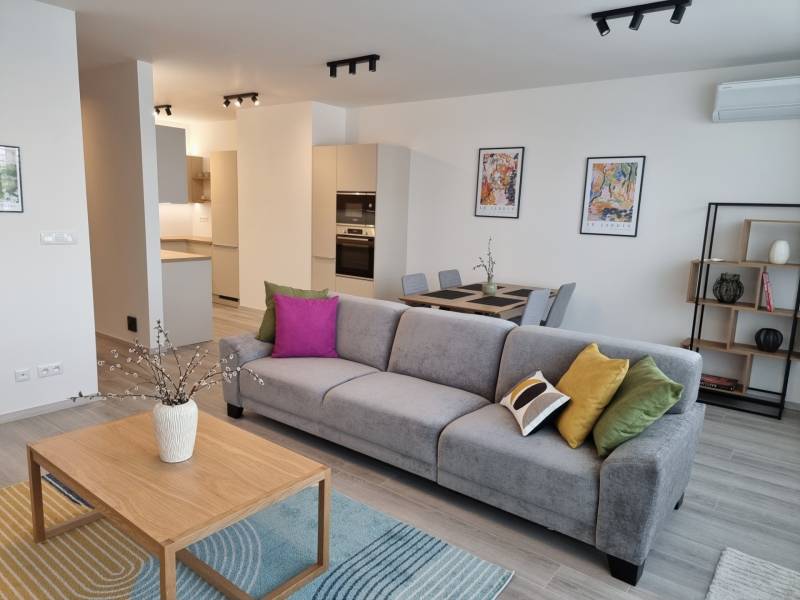 Wohnzimmer mit Sofa, Esstisch und Küche in einer 3-Zimmer-Wohnung.