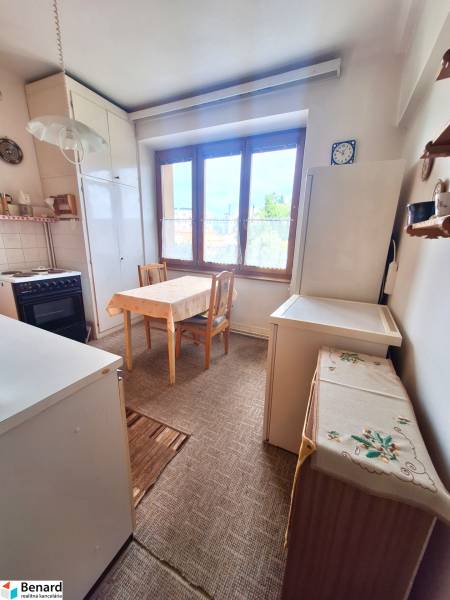 Küche in einer 2-Zimmer-Wohnung mit einem Holzesstisch und einem großen Fenster.